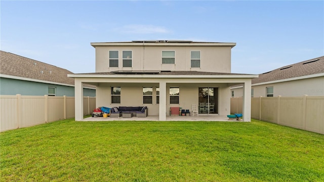 rear view of property with outdoor lounge area, a lawn, and a patio area