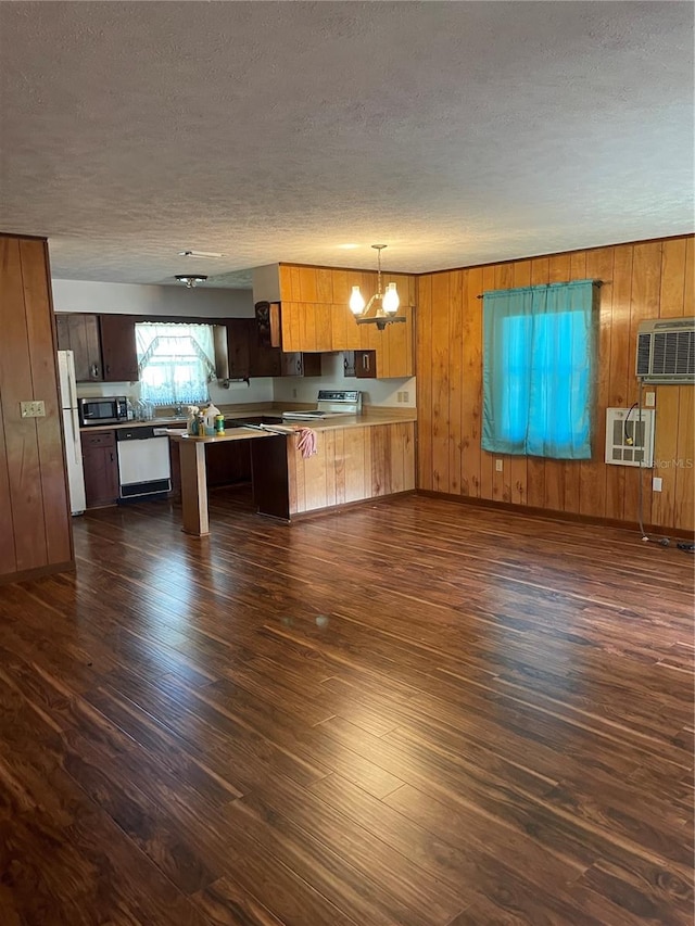 kitchen featuring a textured ceiling, dark hardwood / wood-style flooring, pendant lighting, appliances with stainless steel finishes, and kitchen peninsula