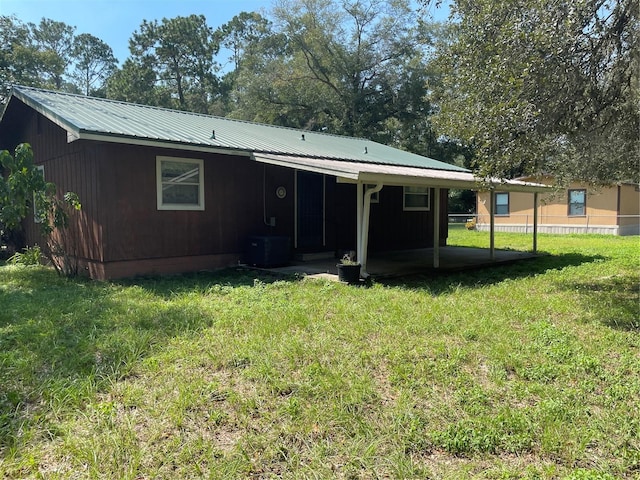 rear view of house featuring a yard and central AC