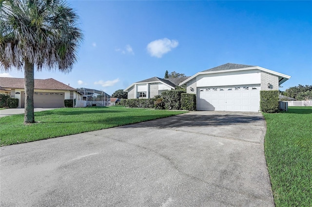 ranch-style house with a garage, a front lawn, and central air condition unit