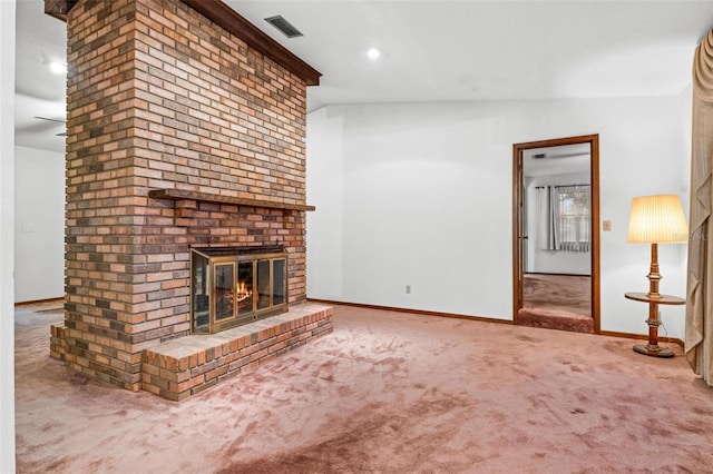 unfurnished living room with vaulted ceiling, a fireplace, and carpet floors