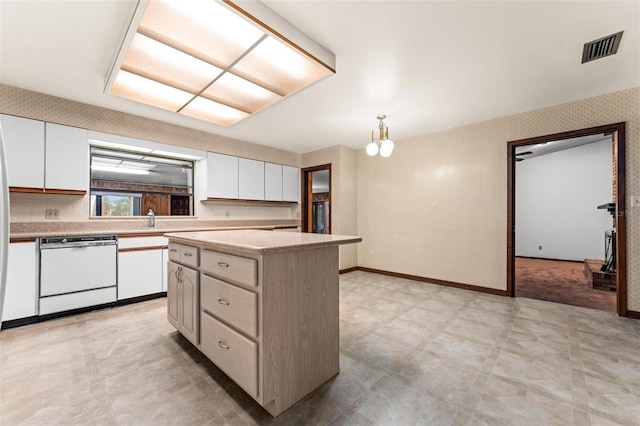 kitchen featuring pendant lighting, white cabinetry, a kitchen island, and white dishwasher