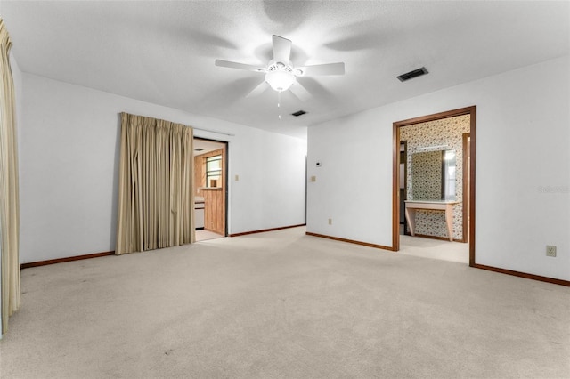 carpeted spare room with a textured ceiling and ceiling fan