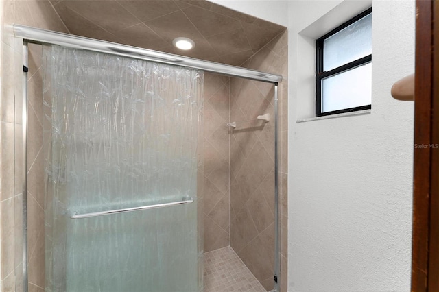 bathroom with a shower with door