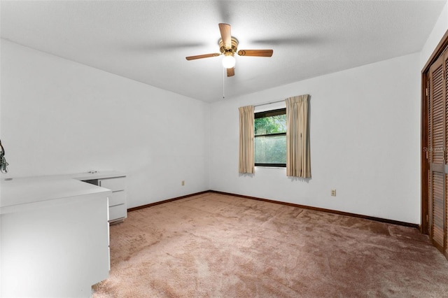 unfurnished bedroom featuring a textured ceiling, carpet flooring, ceiling fan, and lofted ceiling