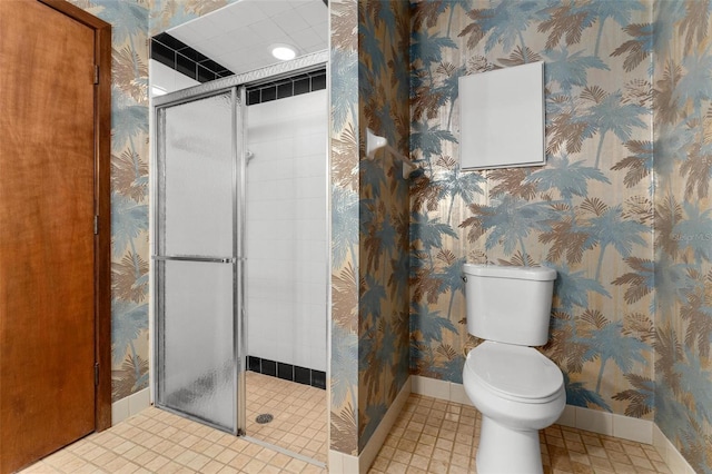 bathroom featuring tile patterned flooring, toilet, and walk in shower