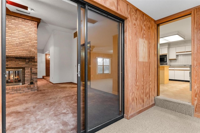 corridor with light carpet, vaulted ceiling, and wooden walls