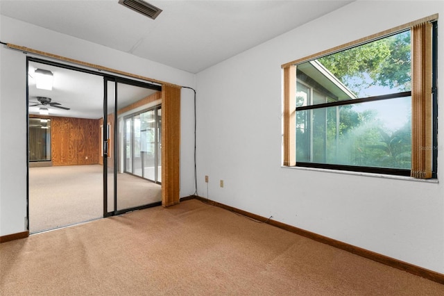 spare room featuring plenty of natural light, ceiling fan, and carpet