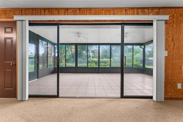 doorway featuring carpet flooring, ceiling fan, and a wealth of natural light