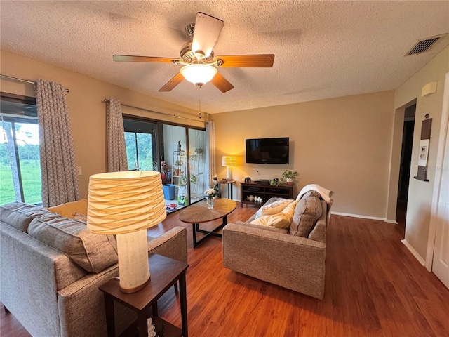 living room featuring a textured ceiling, wood-type flooring, and ceiling fan