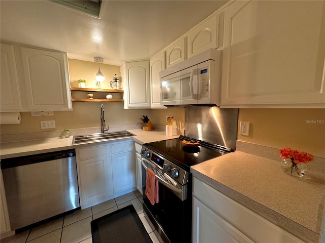 kitchen with decorative light fixtures, light tile patterned floors, appliances with stainless steel finishes, sink, and white cabinetry