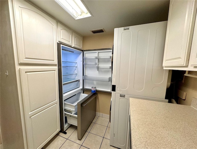 kitchen featuring light tile patterned floors and white cabinetry