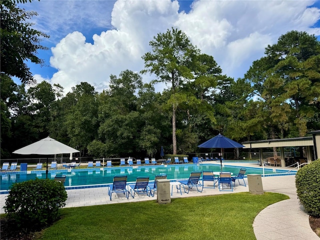 view of pool featuring a lawn