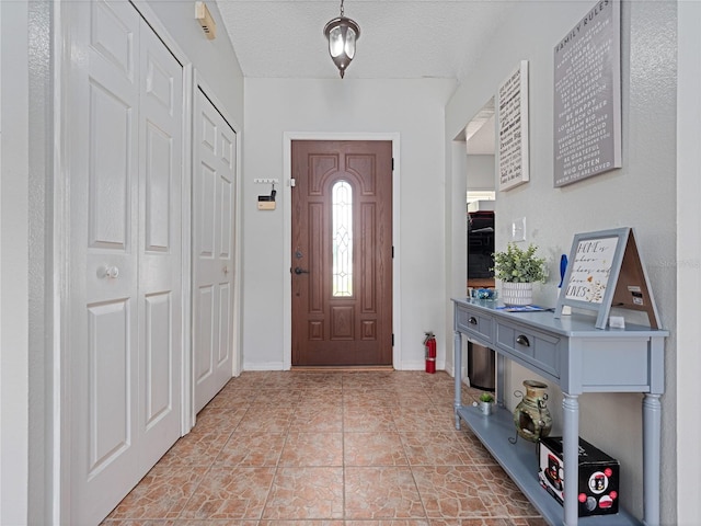 tiled foyer entrance featuring a textured ceiling