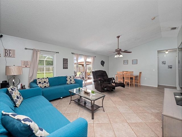 tiled living room with a textured ceiling, ceiling fan, and vaulted ceiling