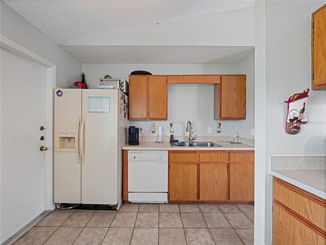 kitchen with a textured ceiling, sink, white appliances, and light tile patterned flooring