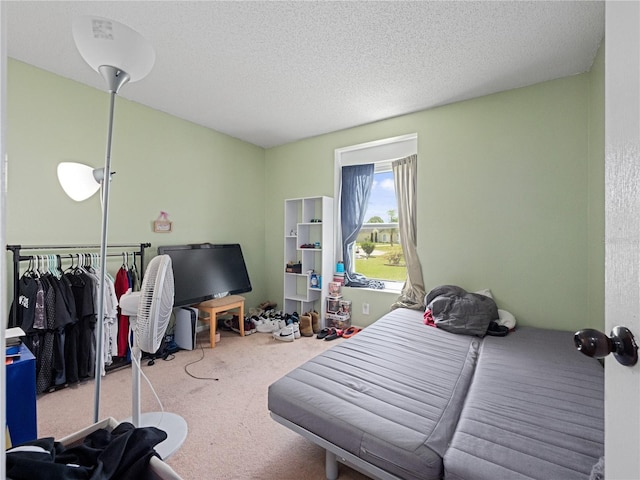 carpeted bedroom featuring a textured ceiling and a closet