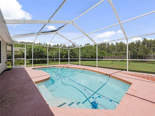 view of swimming pool with glass enclosure, a yard, and a patio