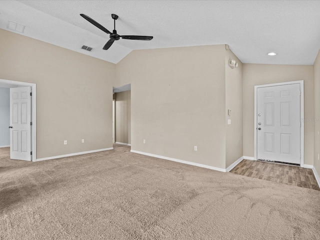 spare room with visible vents, vaulted ceiling, and carpet flooring