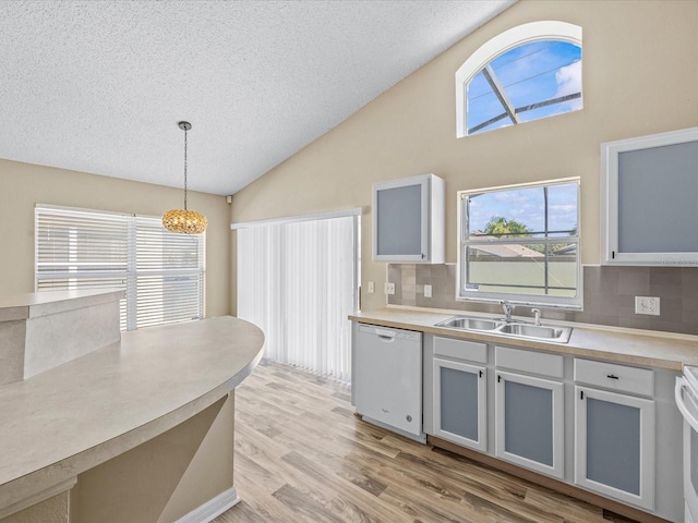 2977 Kokomo Loop, Haines City, FL 33844 - kitchen featuring dishwasher, backsplash, a chandelier, a textured ceiling, and light wood-style floors