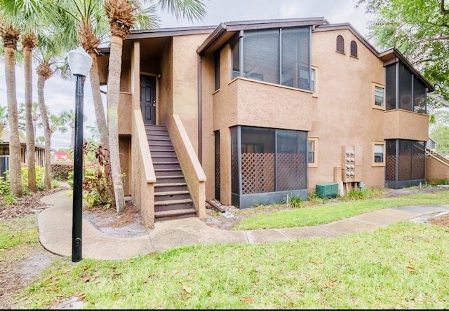 back of property with a yard and central air condition unit