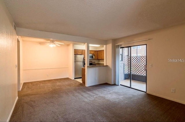 spare room with a textured ceiling, carpet, and ceiling fan