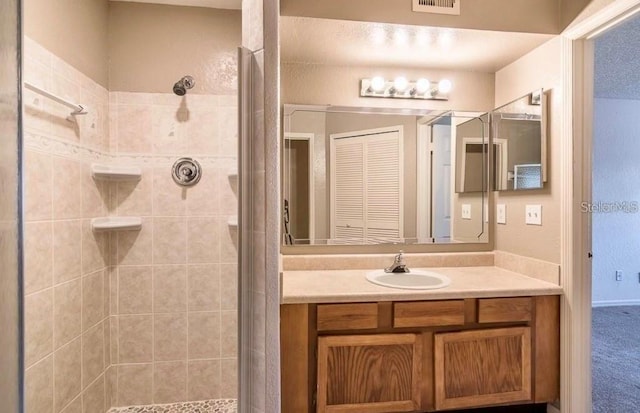 bathroom featuring a shower with door and vanity