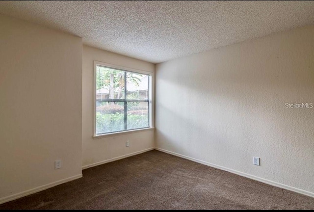 carpeted spare room featuring a textured ceiling