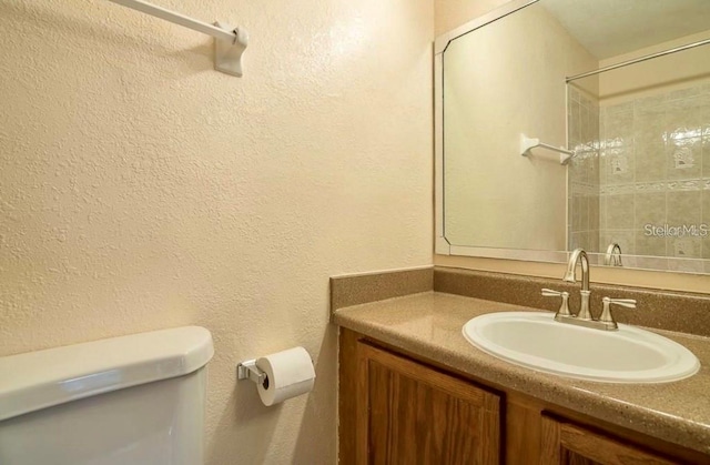 bathroom with a shower, toilet, and vanity