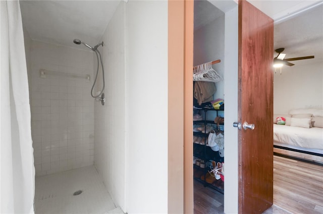 bathroom featuring hardwood / wood-style floors, walk in shower, and ceiling fan