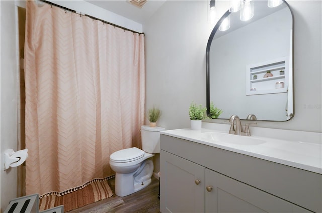 bathroom with toilet, hardwood / wood-style flooring, and vanity