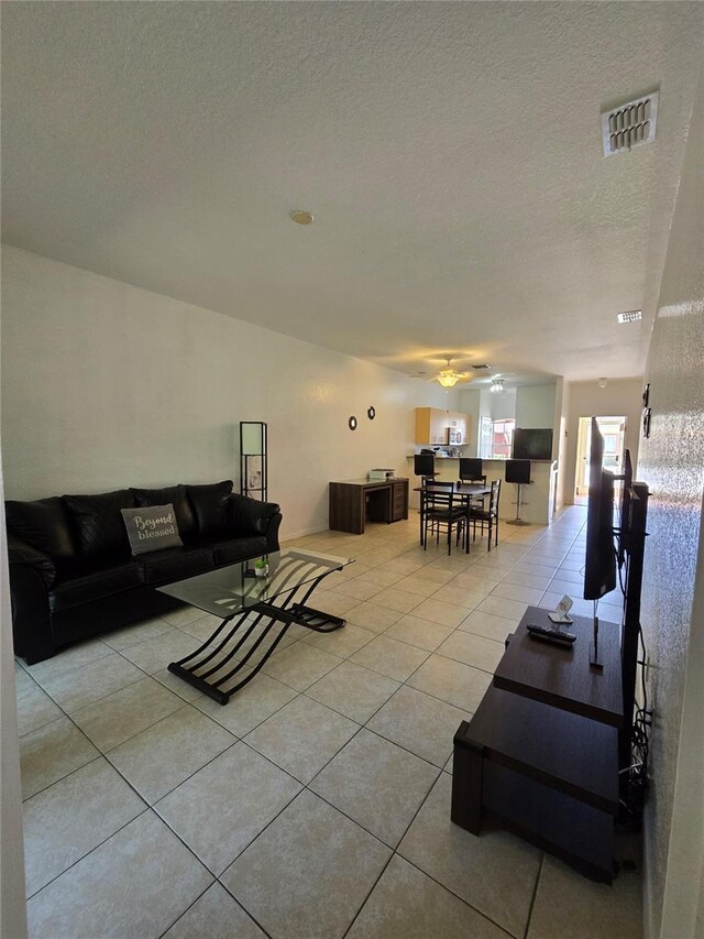 tiled living room featuring a textured ceiling