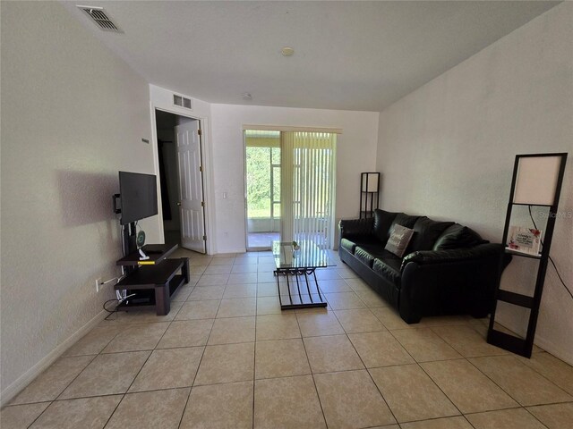 living room with visible vents, baseboards, and light tile patterned floors