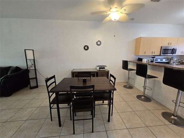 dining space with light tile patterned floors, ceiling fan, and baseboards