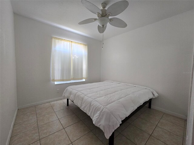 tiled bedroom featuring ceiling fan