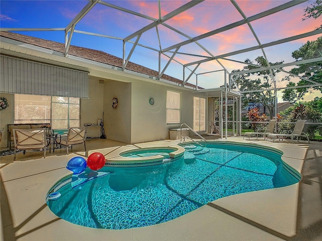 pool at dusk featuring a lanai, a patio area, and an in ground hot tub