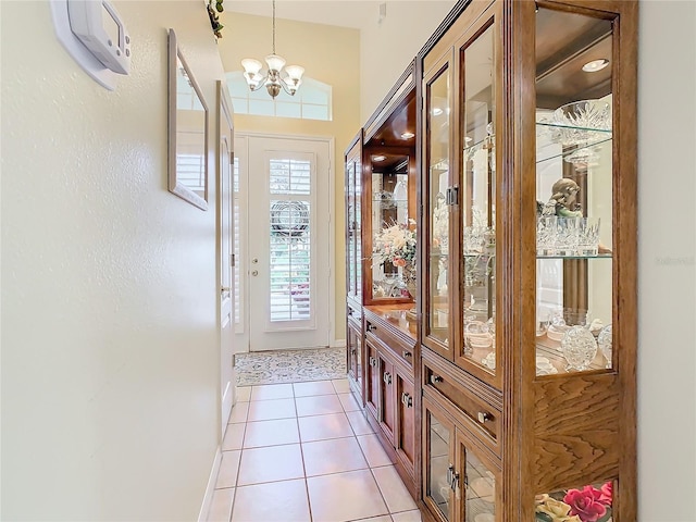 interior space featuring light tile patterned floors, a notable chandelier, and vaulted ceiling