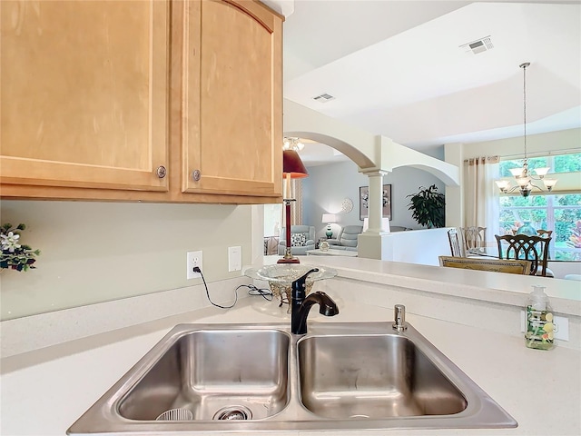 kitchen featuring hanging light fixtures, sink, light brown cabinets, and an inviting chandelier