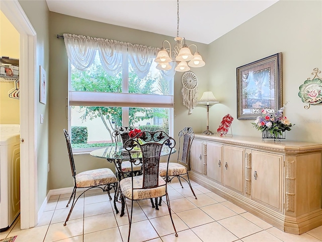 tiled dining area with plenty of natural light, an inviting chandelier, and washer / clothes dryer