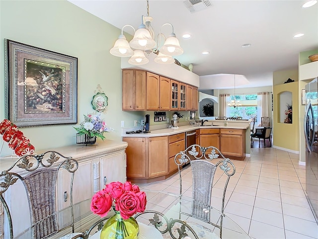 kitchen featuring a notable chandelier, light tile patterned floors, stainless steel dishwasher, kitchen peninsula, and sink