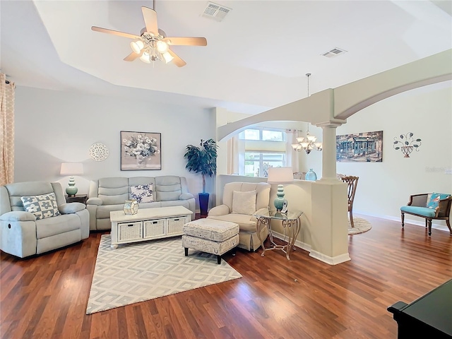 living room featuring dark wood-type flooring and ceiling fan with notable chandelier