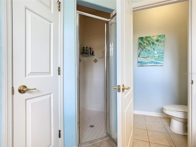 bathroom with tile patterned flooring, toilet, and walk in shower