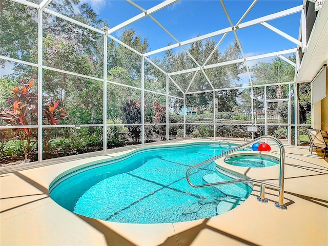 view of swimming pool featuring glass enclosure, an in ground hot tub, and a patio