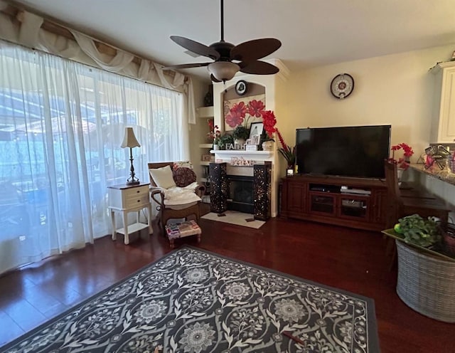 living room featuring dark wood-type flooring and ceiling fan