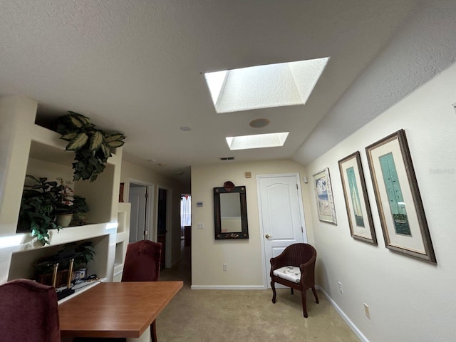 home office with light carpet, a textured ceiling, and lofted ceiling with skylight