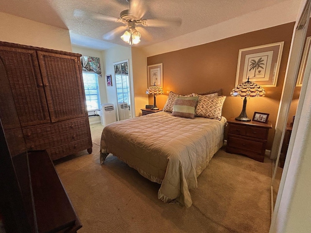 bedroom featuring light carpet, a textured ceiling, and ceiling fan