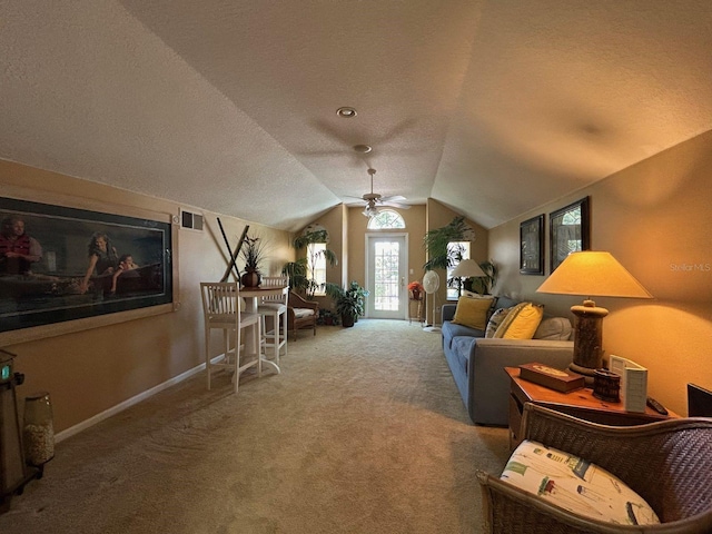 carpeted living room featuring lofted ceiling, ceiling fan, and a textured ceiling