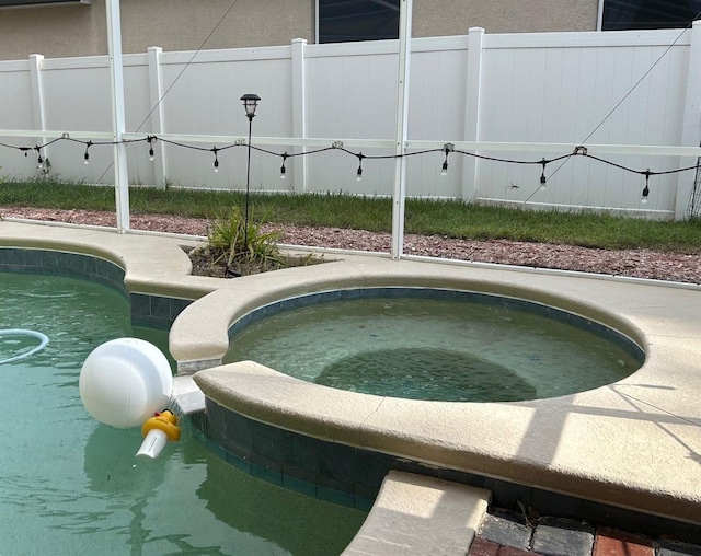 view of swimming pool featuring an in ground hot tub