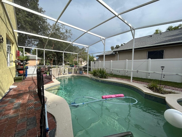 view of pool featuring glass enclosure and a patio area