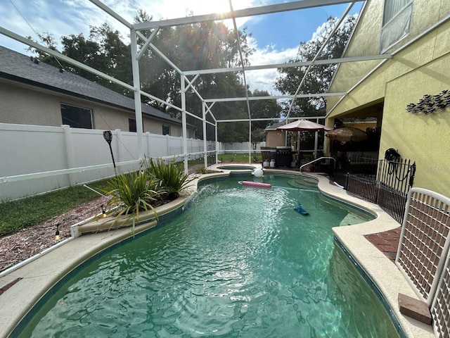 view of swimming pool with a patio area, an in ground hot tub, and a lanai